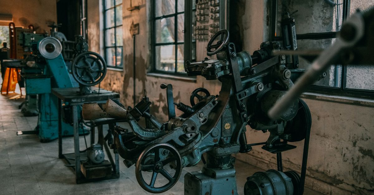 Old industrial machines in an abandoned workshop with vintage tools and equipment.